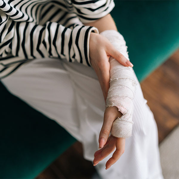 Person holding their arm that is in a cast