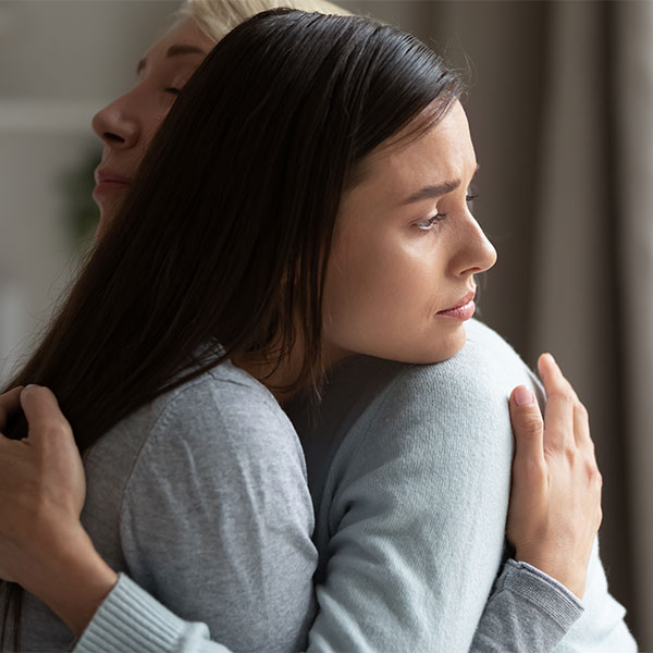 People hugging sadly