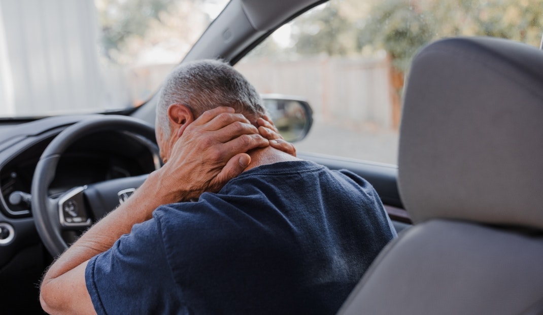 A man holding his neck in pain after an accident