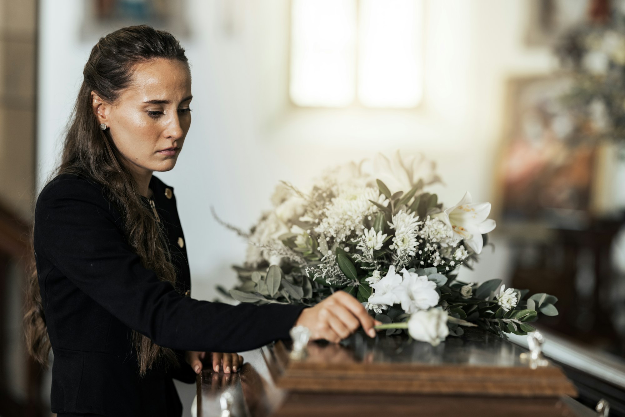 Woman placing a flower on a casket