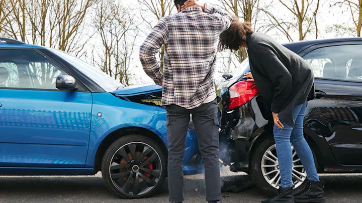 Two drivers inspecting the damage after a car collision