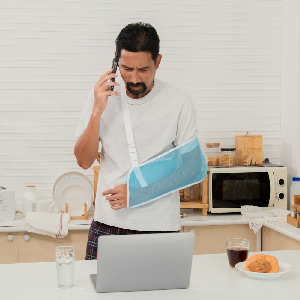 man in sling on the phone