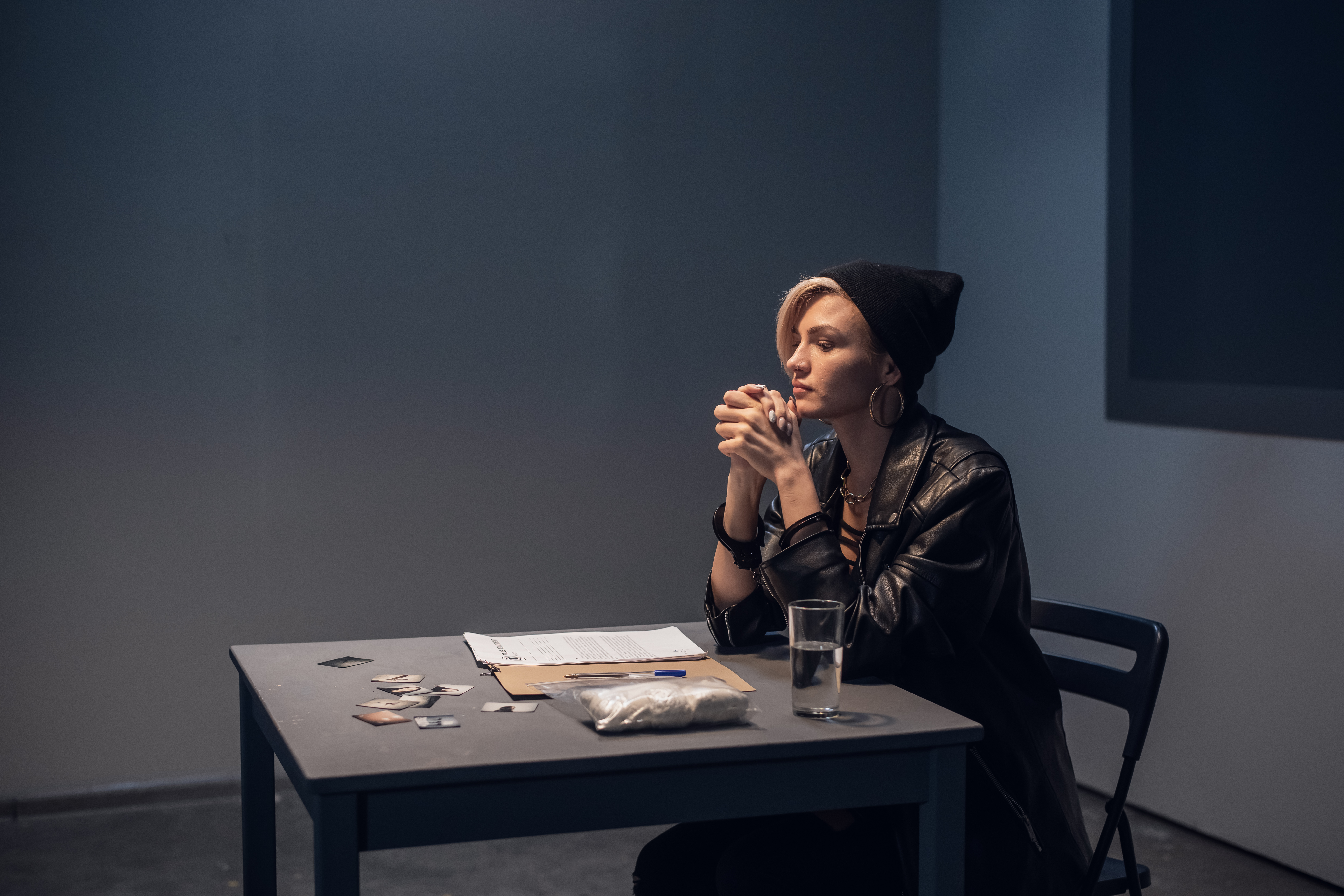 girl in interrogation room with drugs on the table