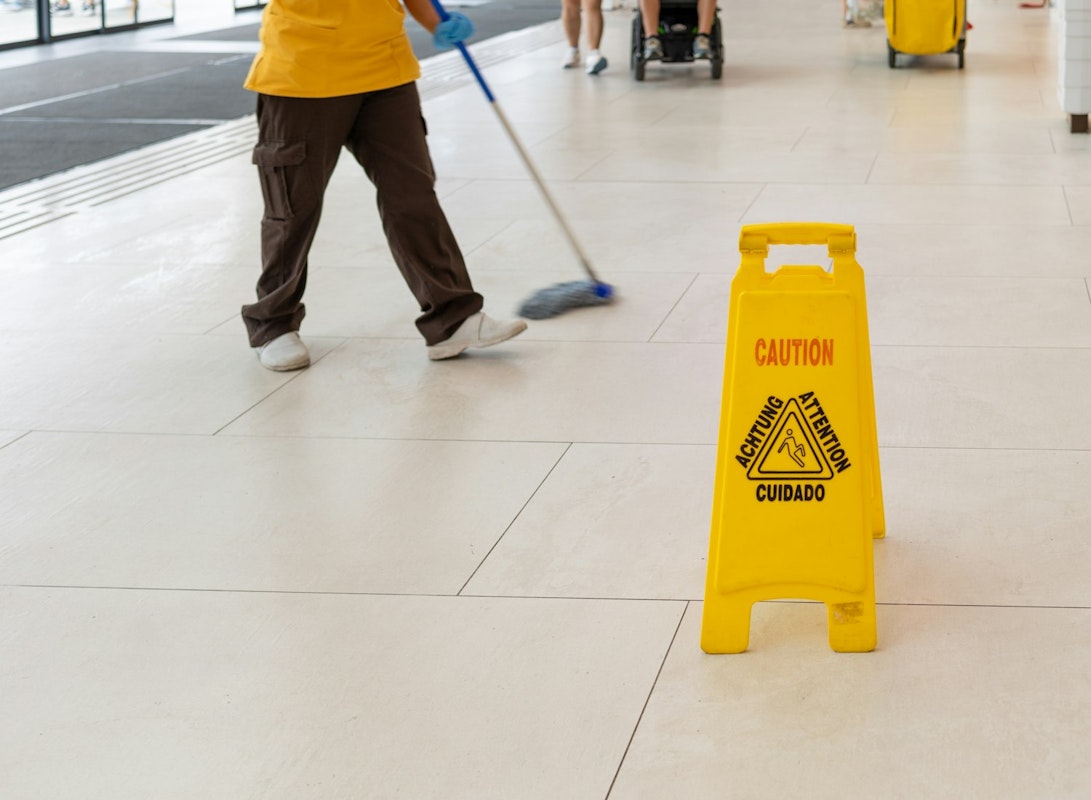 wet floor sign and person mopping