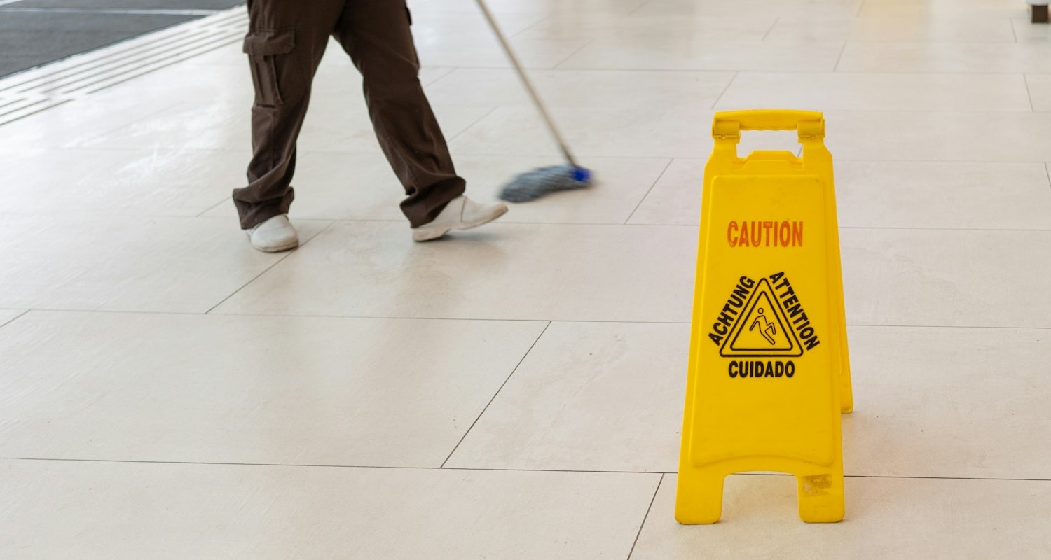 wet floor sign and person mopping