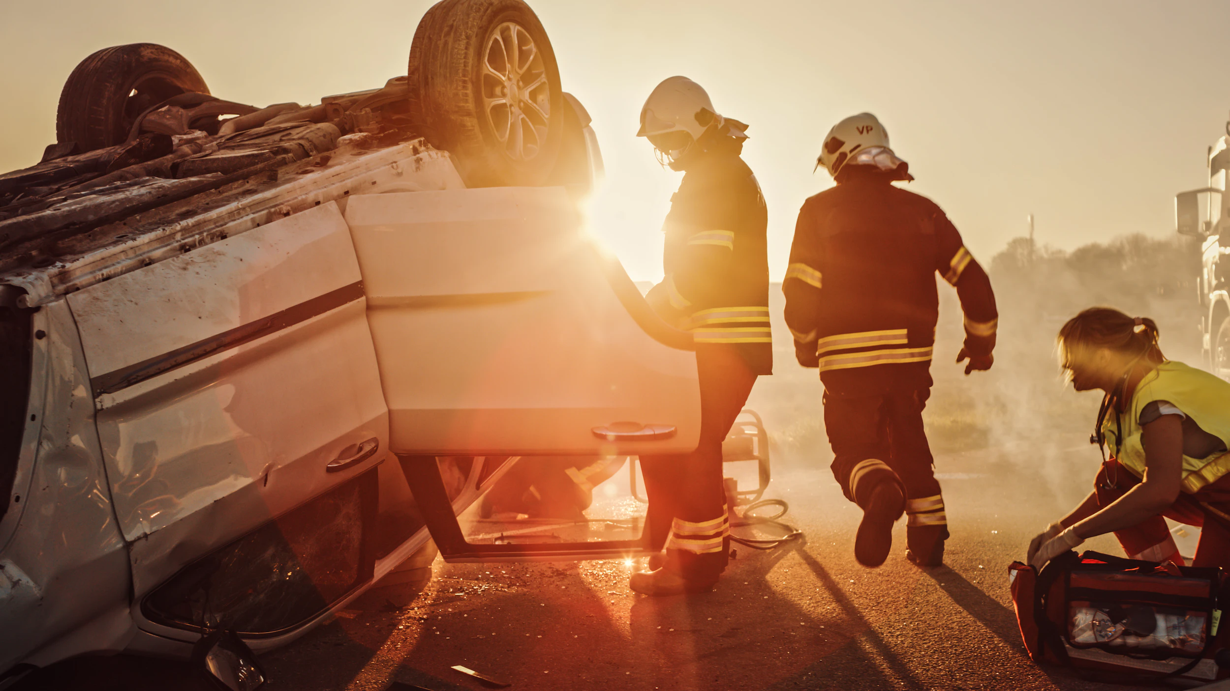 Firefighters and a paramedic responding to a rollover car accident
