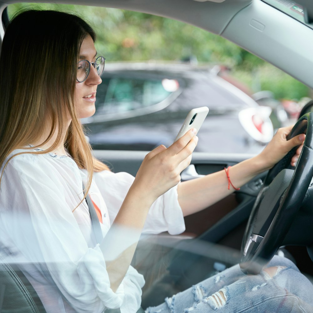 Woman looking at her phone while driving