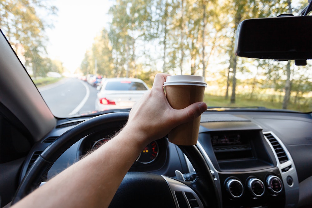Man eating and drinking while driving