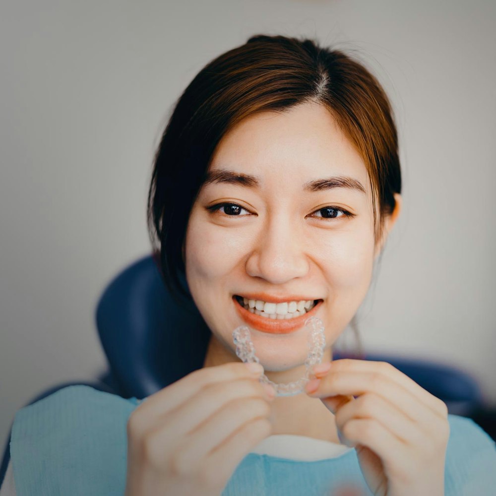 Smiling woman holding Invisalign tray