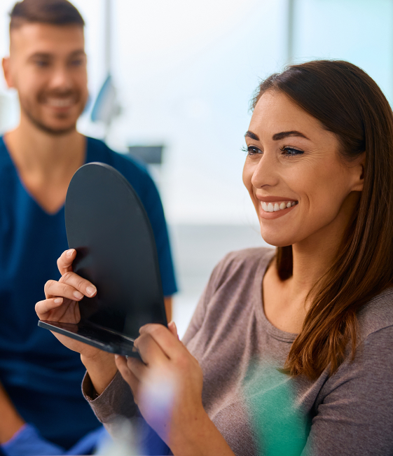 Happy restorative dentistry patient looking in the mirror