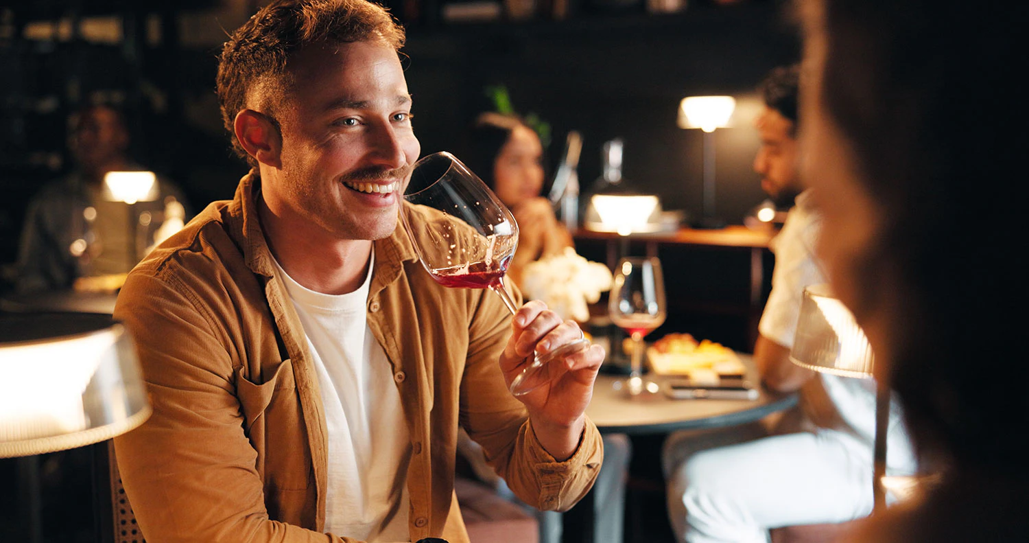 Man smiling and drinking wine