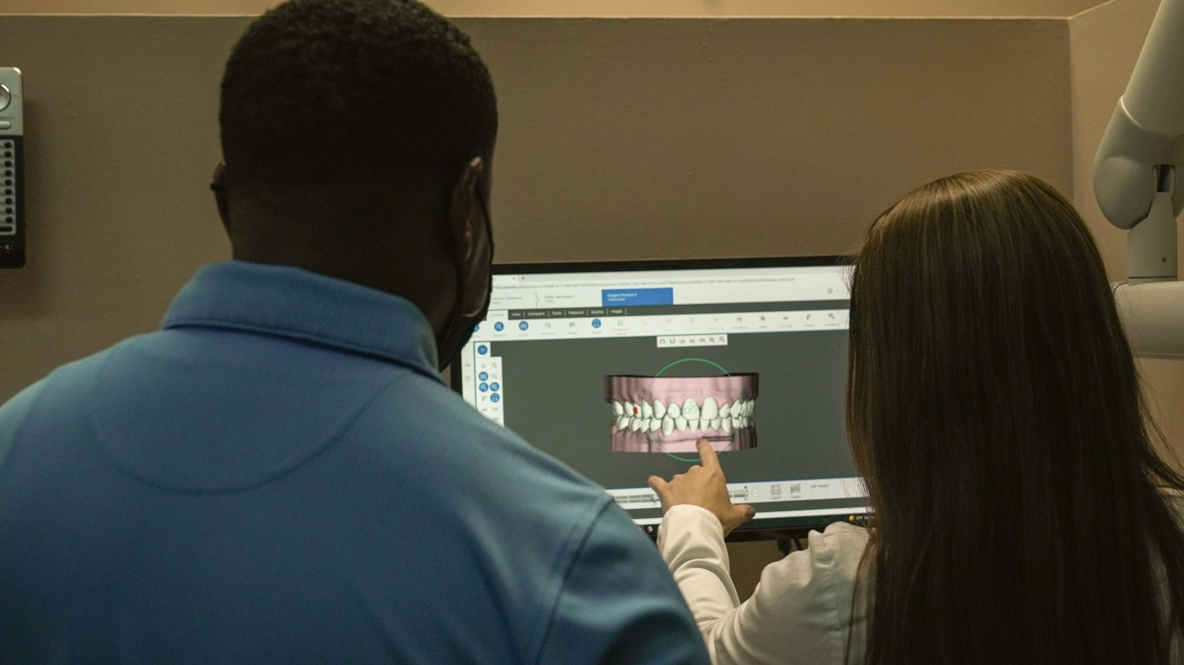 Dental staff educating patient using dental software