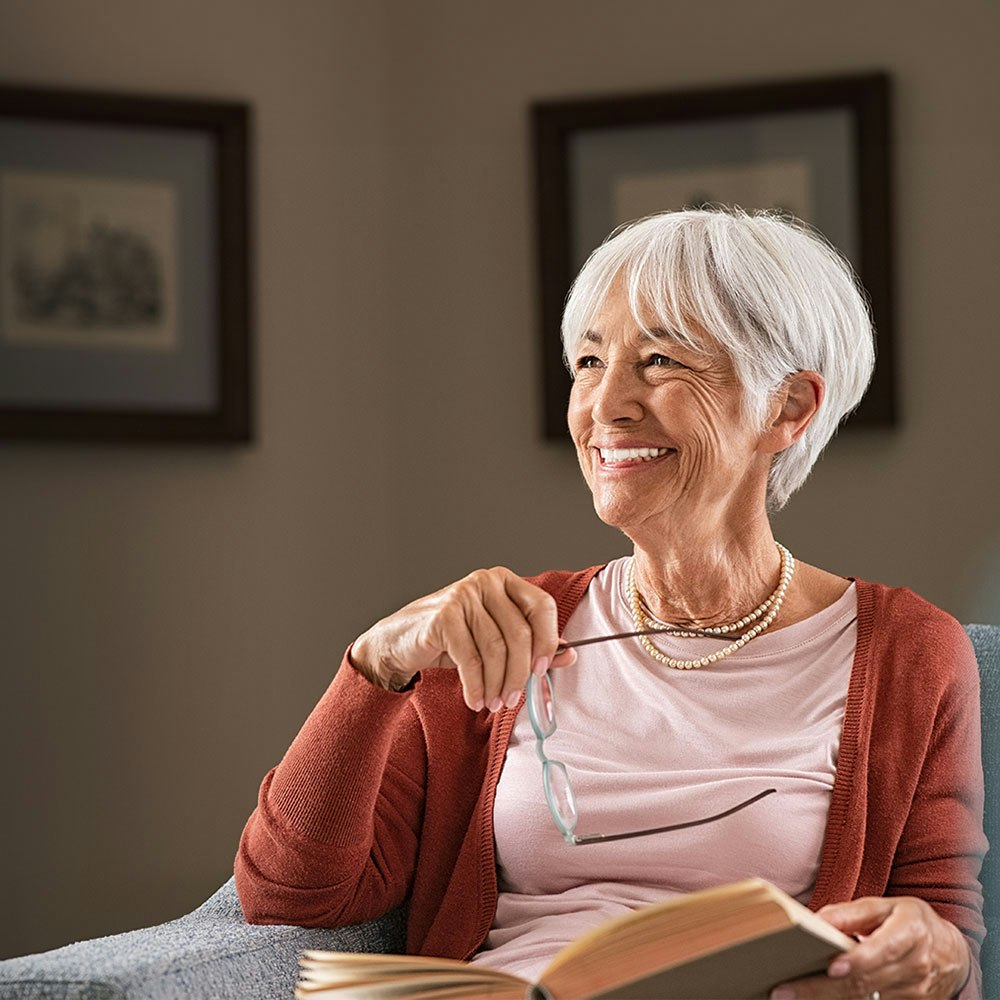 Older woman smiling while reading