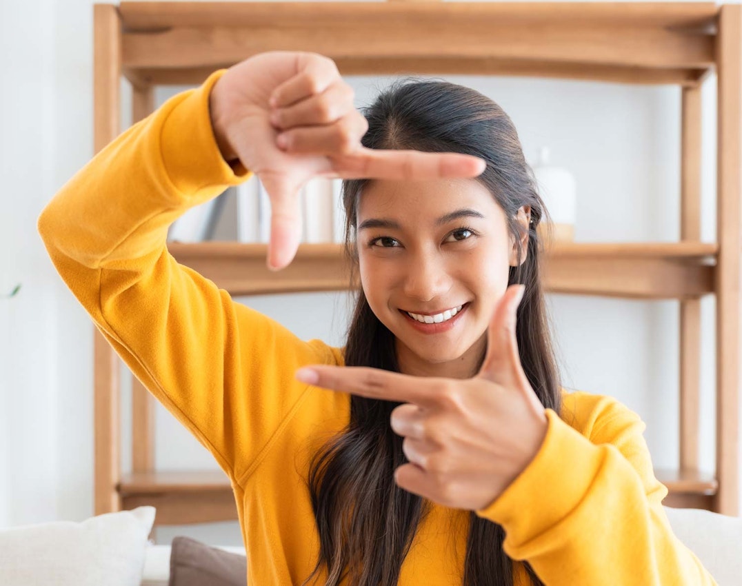 Woman framing her face with fingers like a movie director
