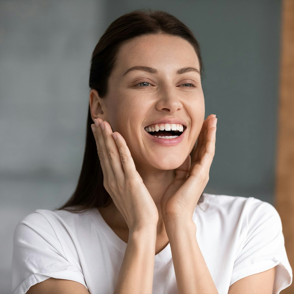 Woman smiling with hands framing face