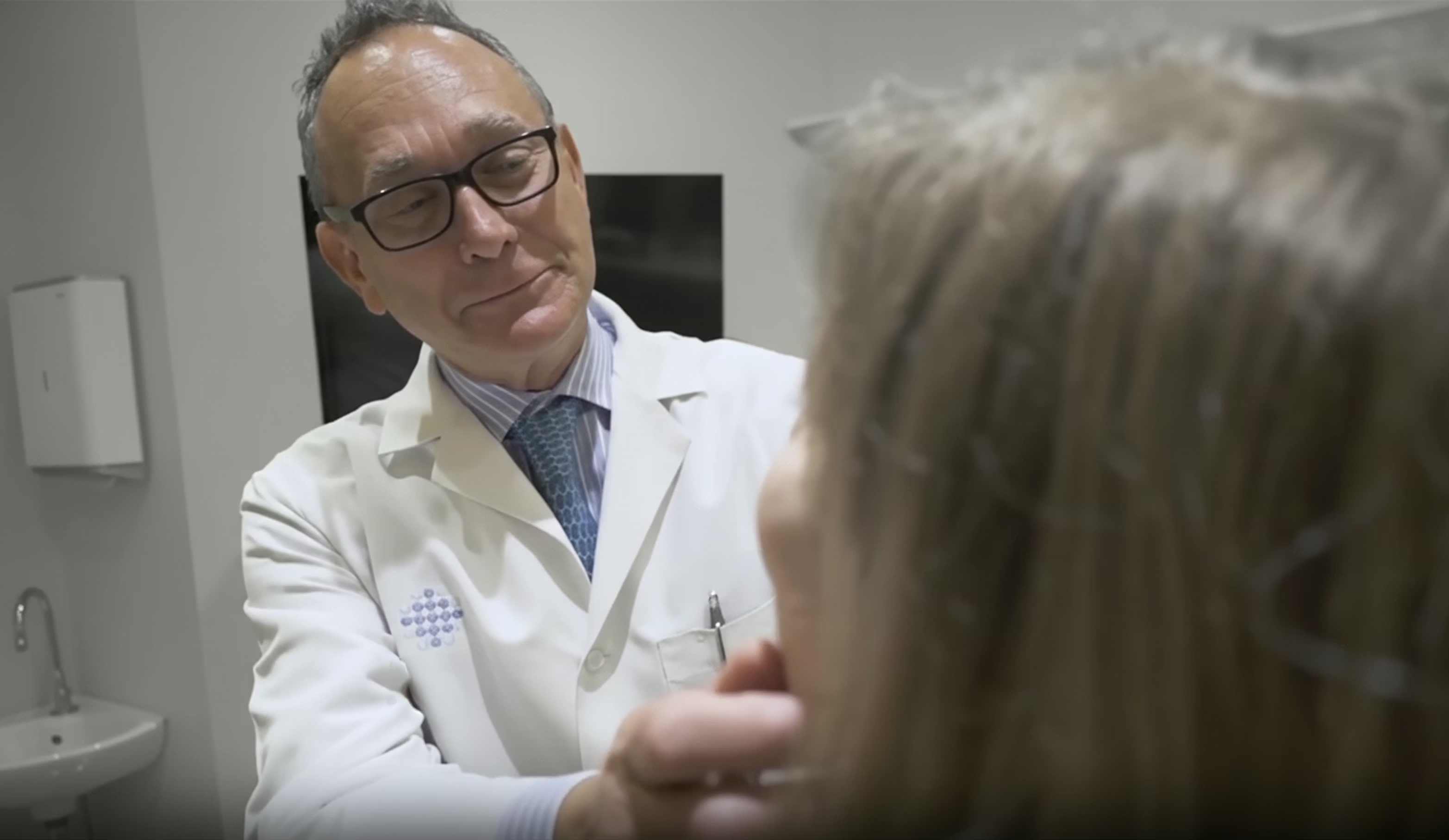 Dr. Sherris looking at a patient's face