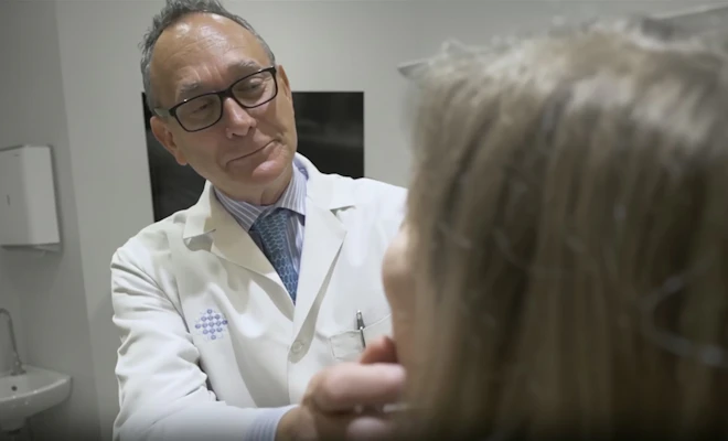 Dr. Sherris looking at a patient's face
