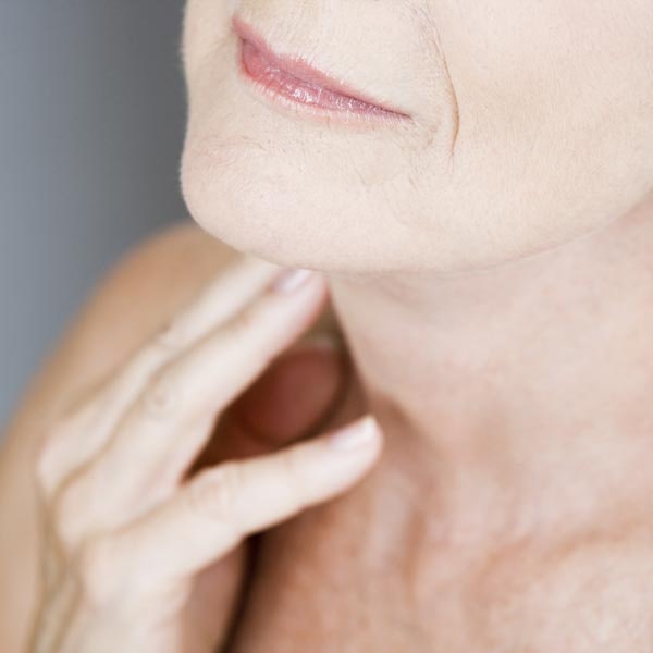 Woman touching neck with hand