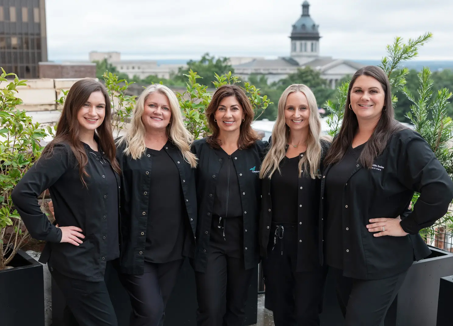Dr. Nick smiling with two patients at a pageant