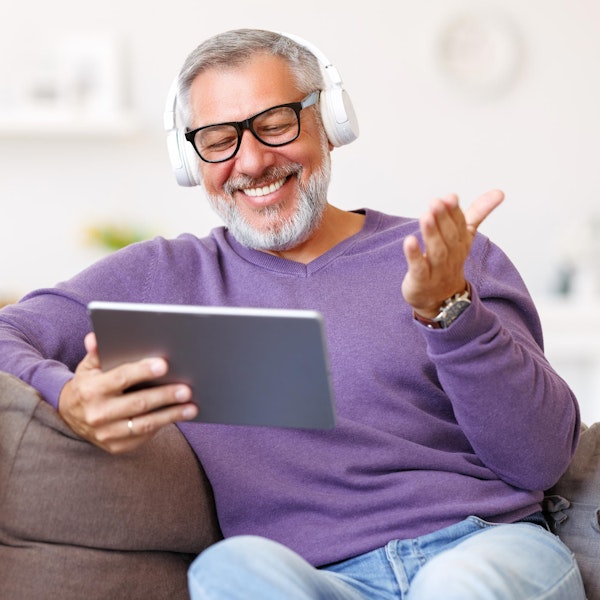 Mature man on tablet while resting at home