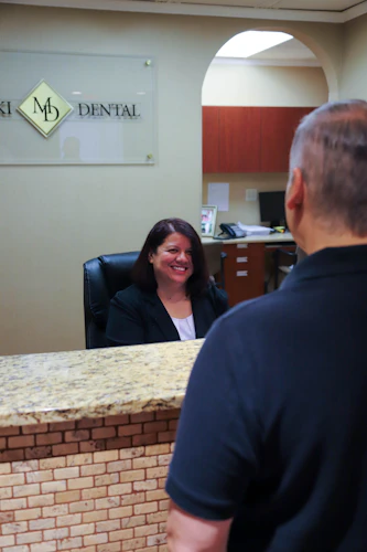 Receptionist smiling at root canal patient