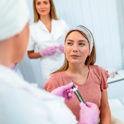 Doctor explaining the microneedling procedure to a patient