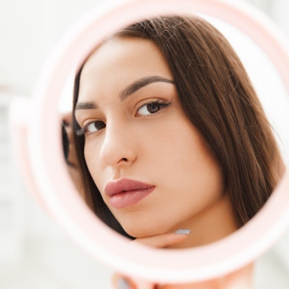 Woman admiring her skin in a mirror