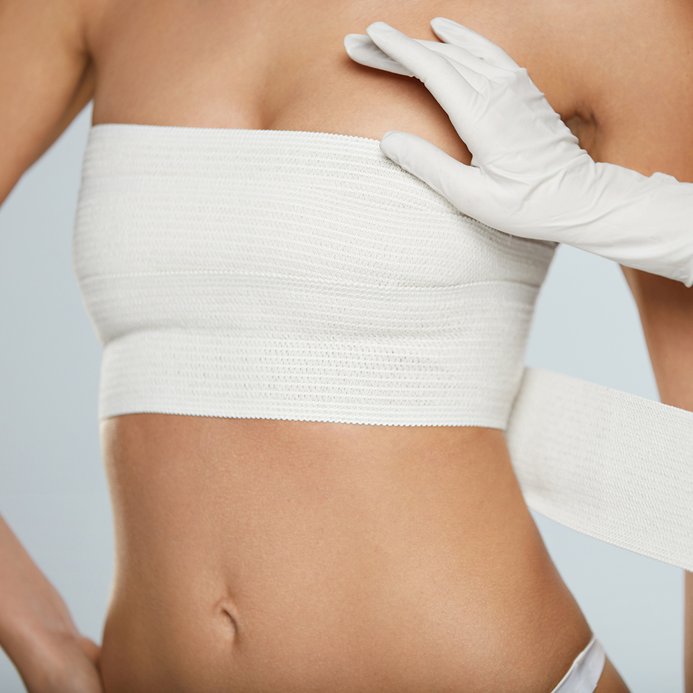 Woman with bandage wrapped around breasts