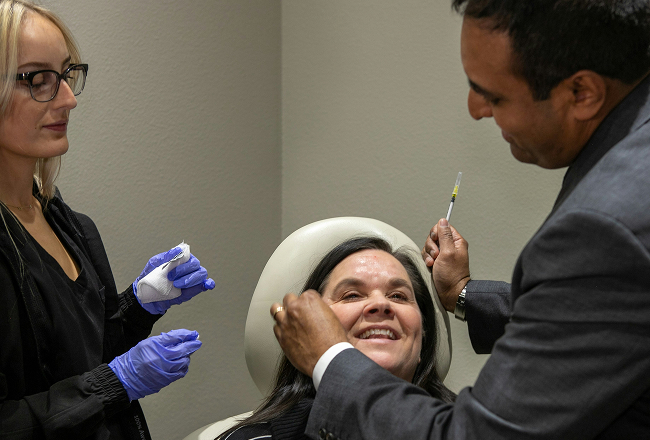 Dr. Rumalla performing injections on a patient