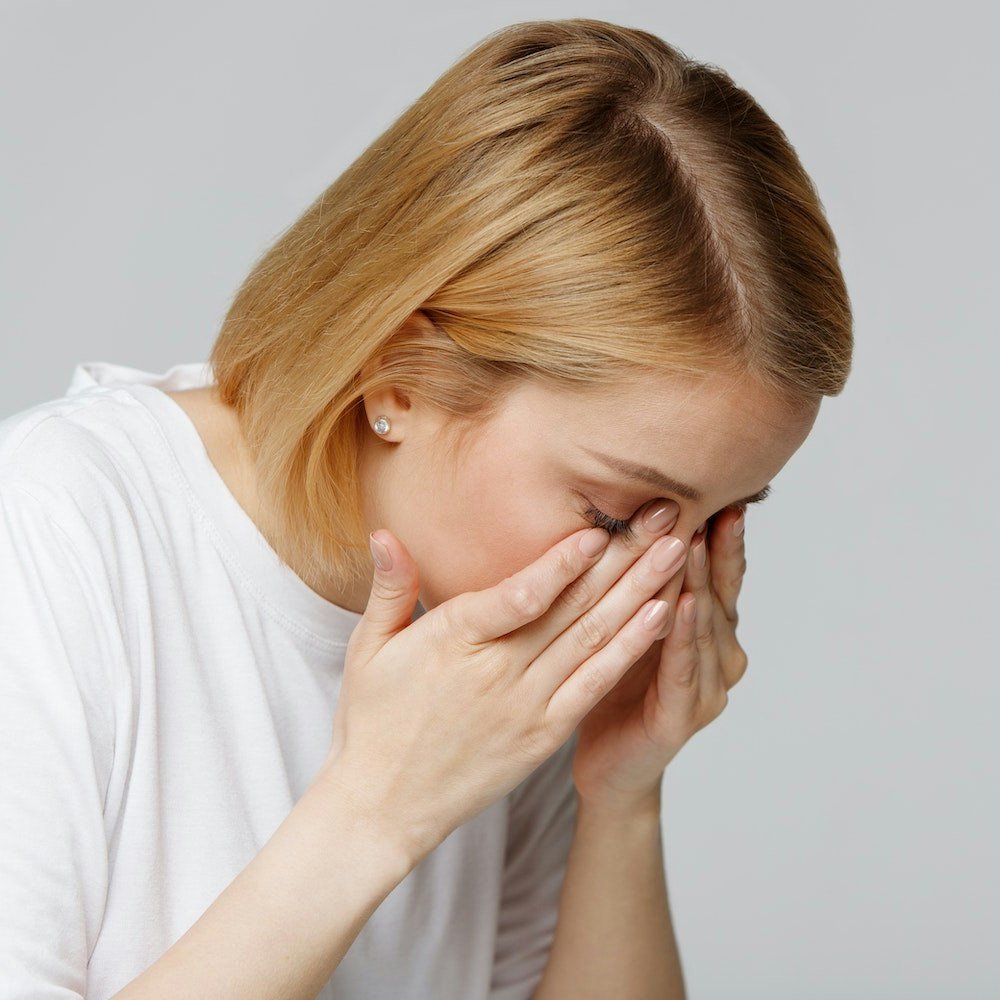woman rubbing eyes