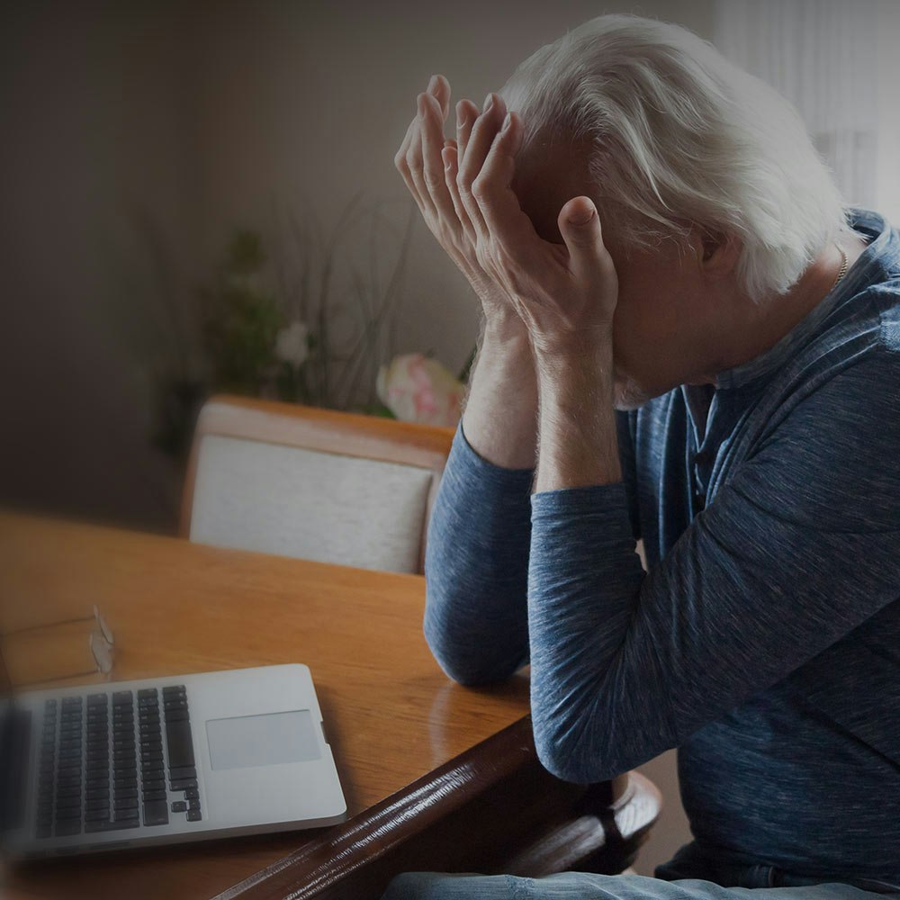 Woman rubbing eyes in front of computer