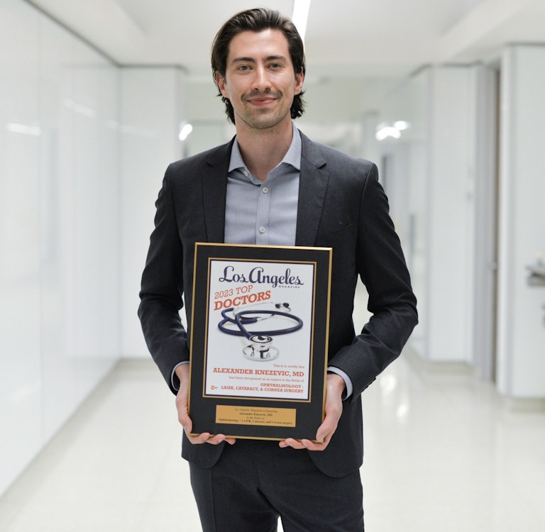 Dr. Alexander Knezevic holding an award