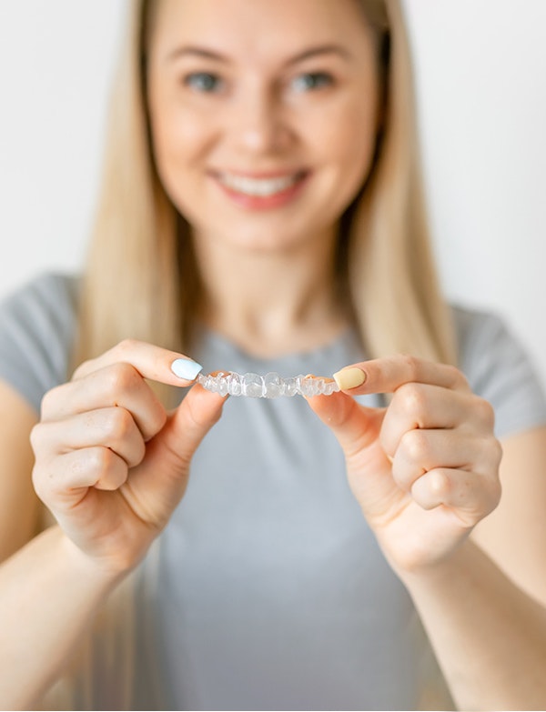 Boston Invisalign patient holding clear aligner