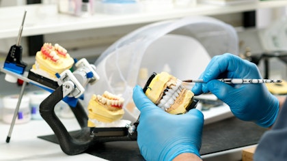 technician working on creating a dental prosthetic in a lab