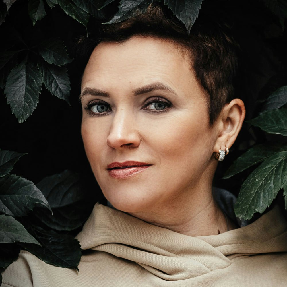 Woman after eyelid surgery surrounded by foliage