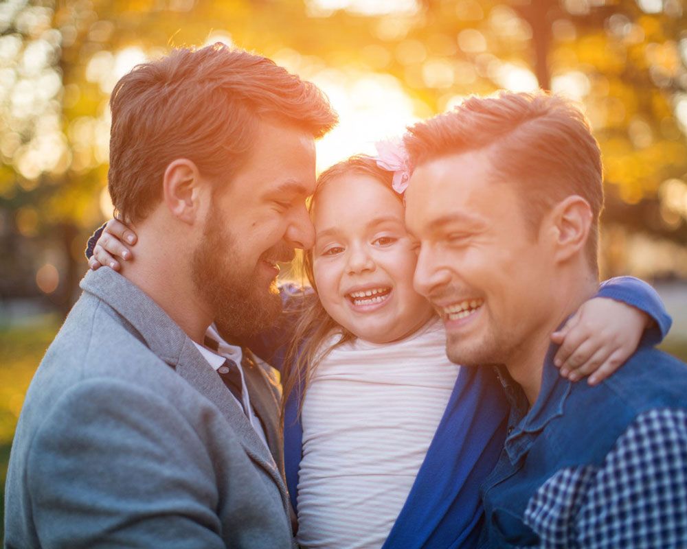 Smiling gay couple with their child