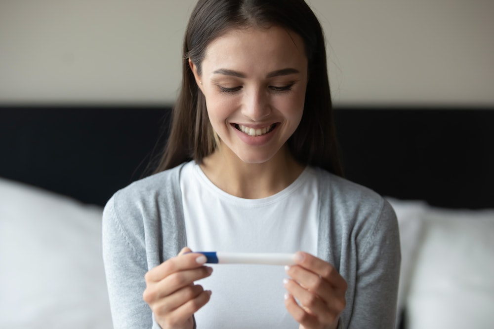 Woman happily looking at a pregnancy test