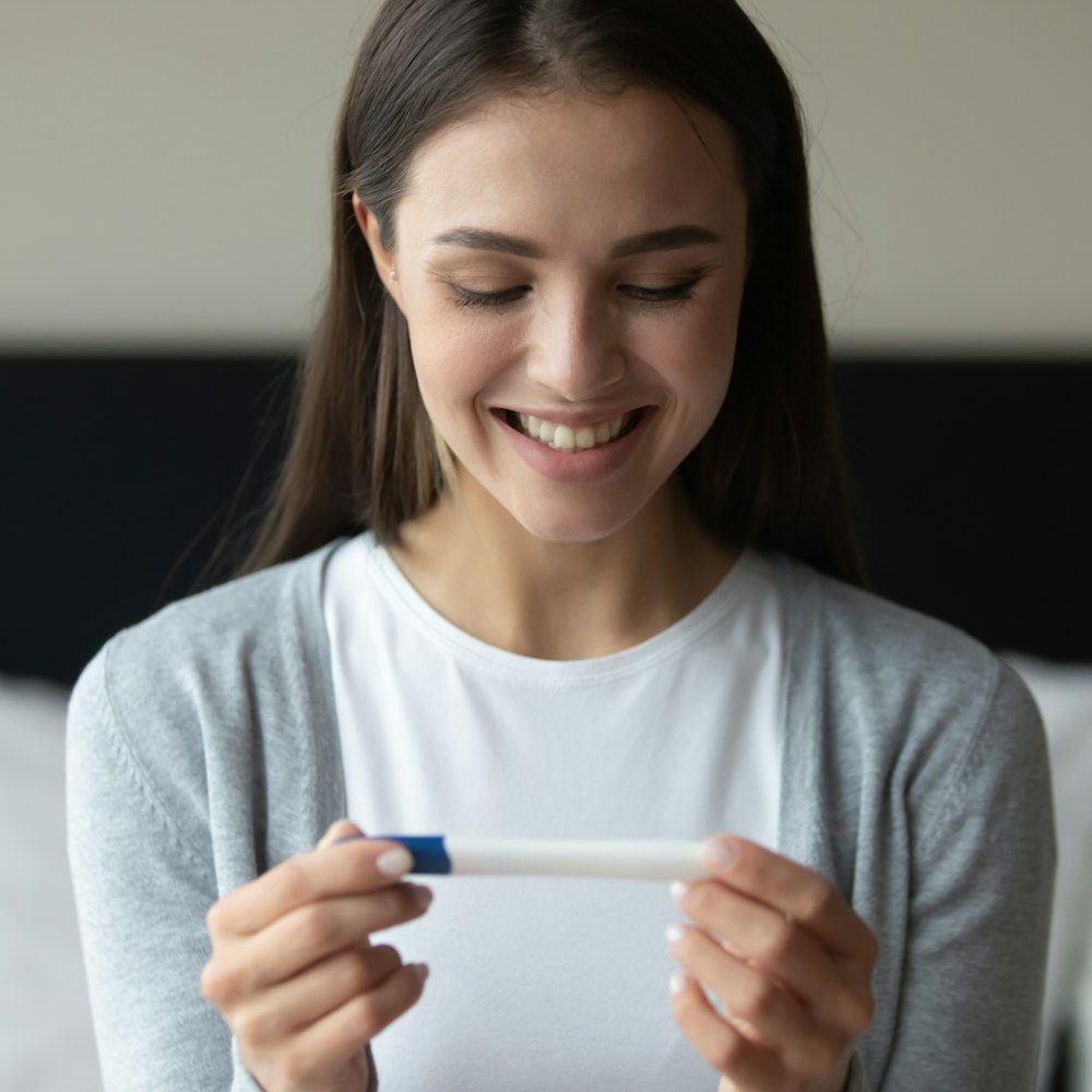 Woman happily looking at a pregnancy test