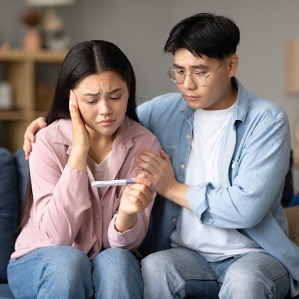 couple looking at pregnancy test disappointed