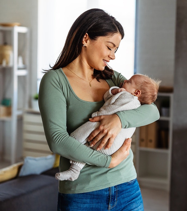Woman in green top holding a newborn baby