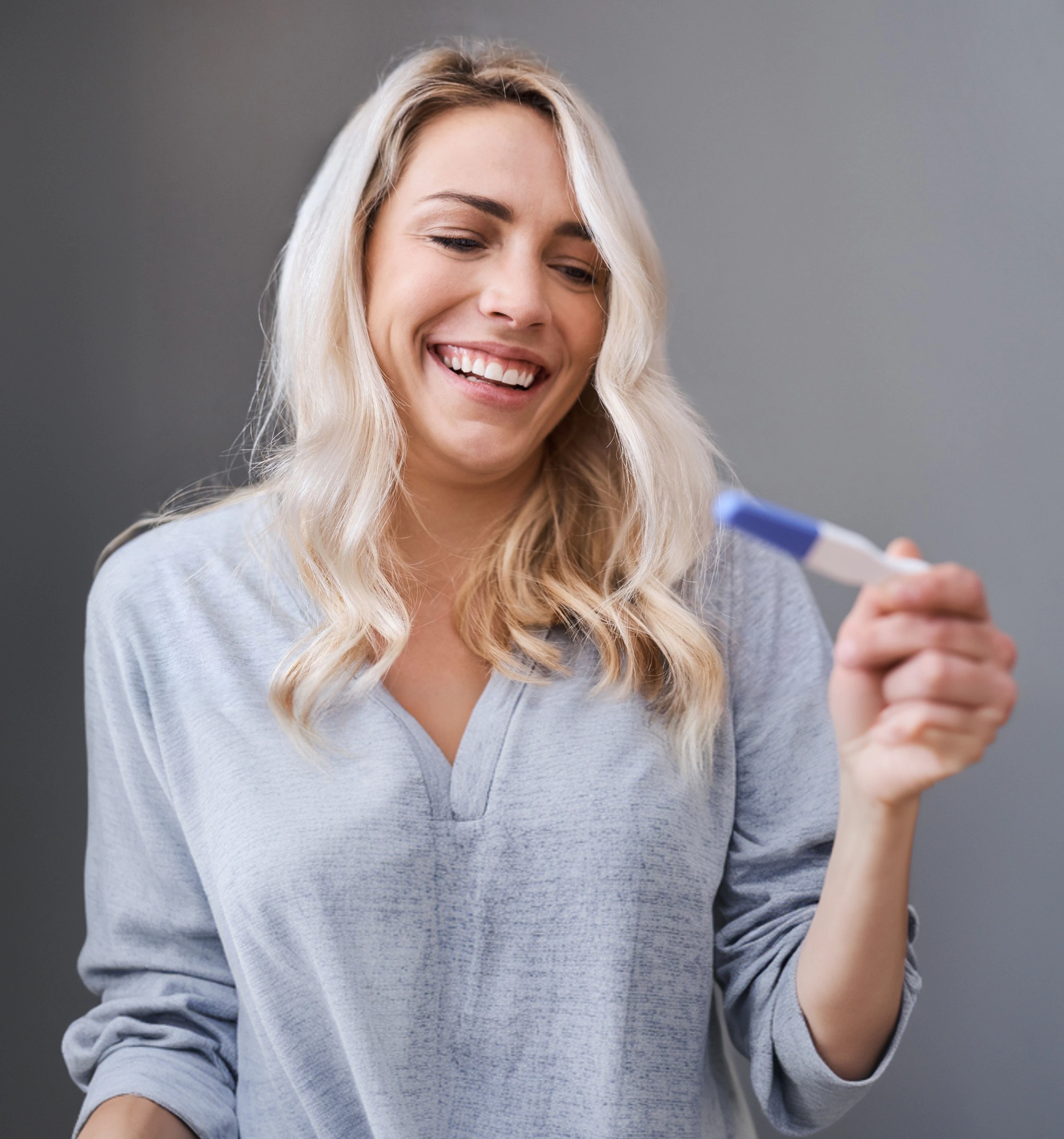 Smiling woman looking at a pregnancy test