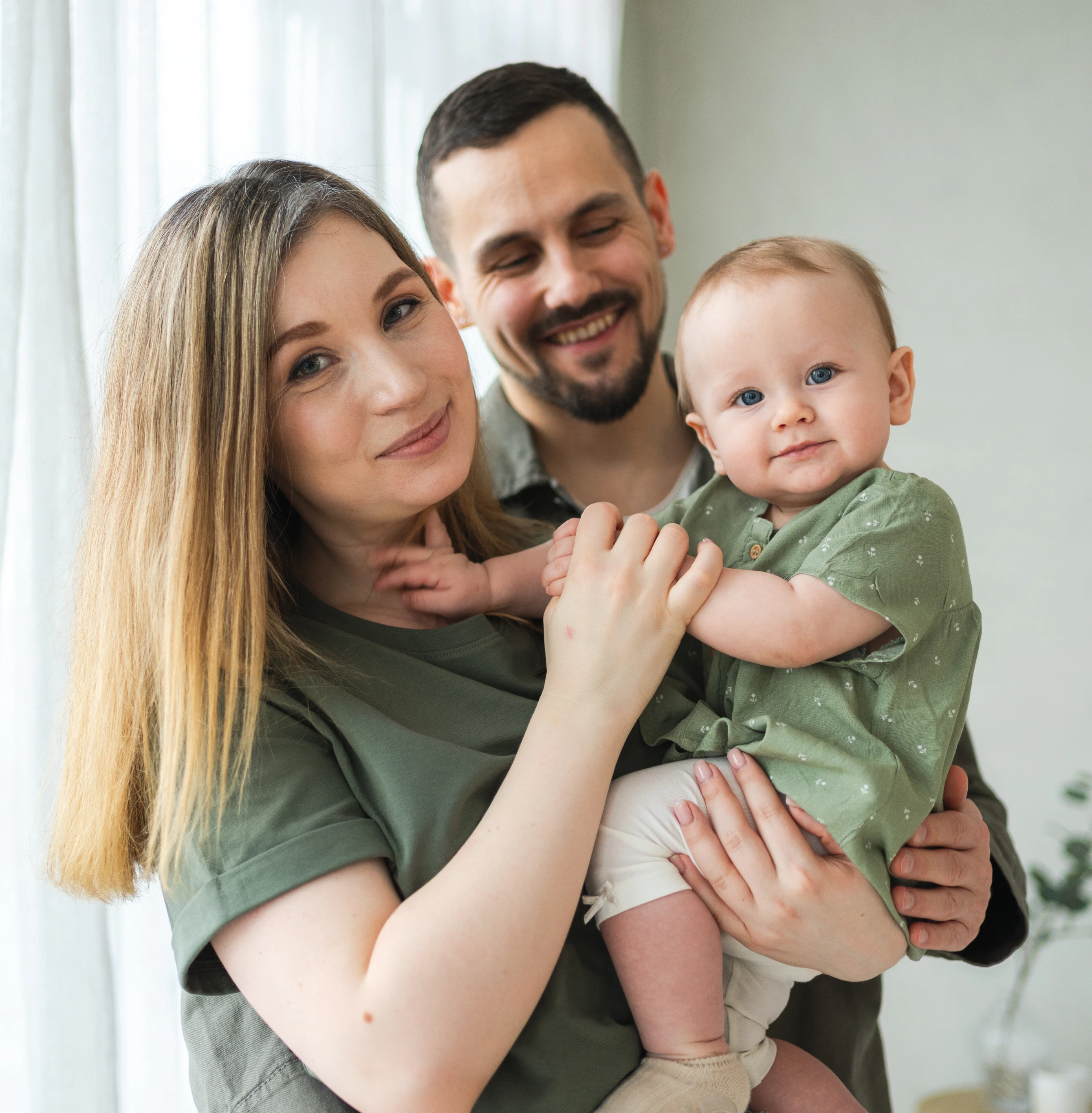 Smiling couple holding their newborn baby