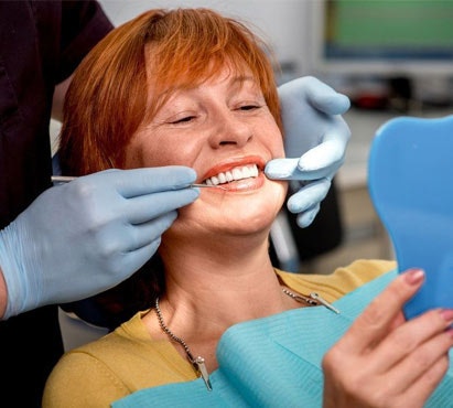 a woman smiling into a mirror