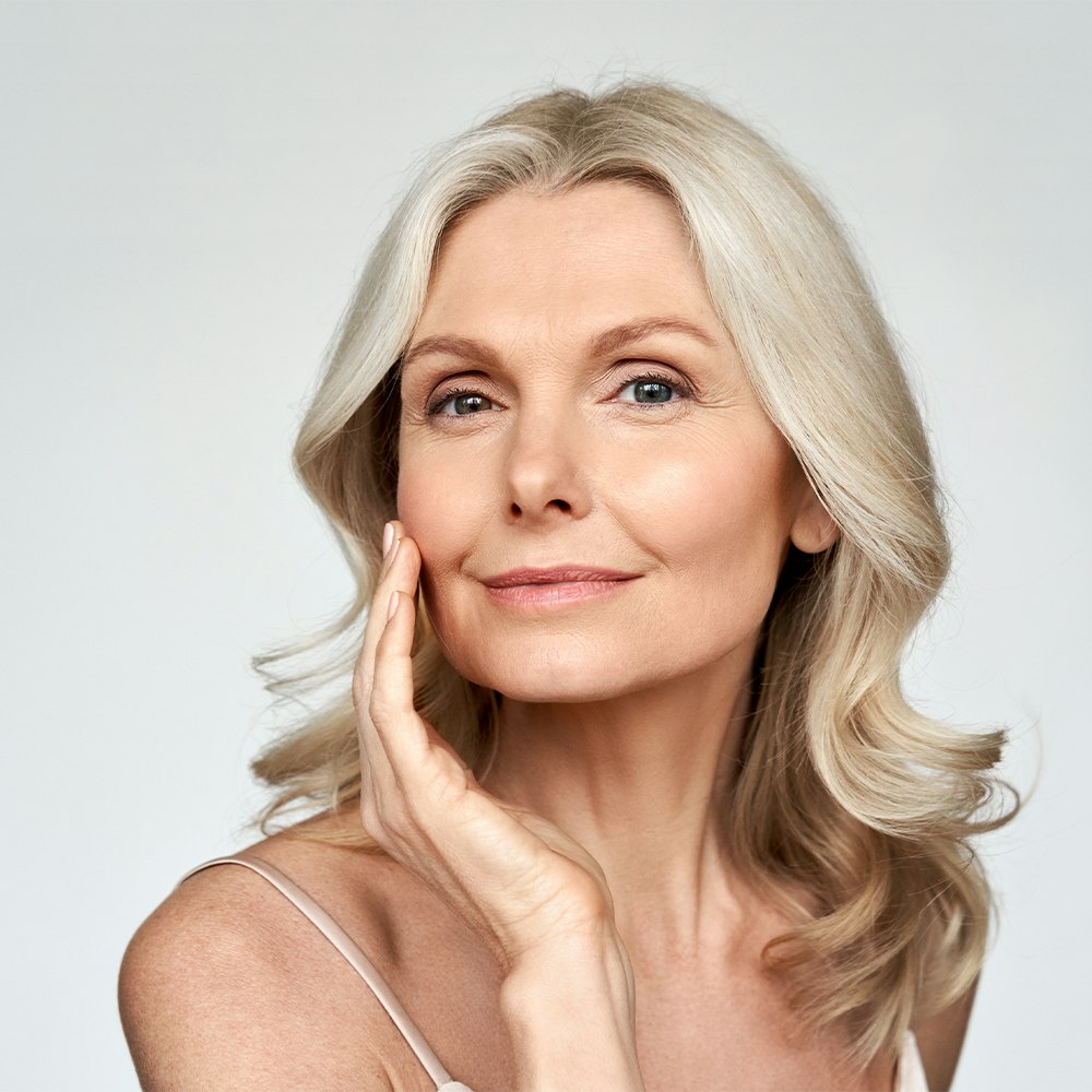 Mature woman touching face