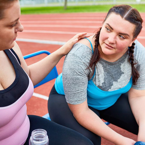 overweight woman taking a break from exercising with a friend