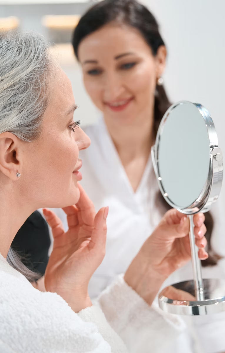 woman looking in a hand held mirror