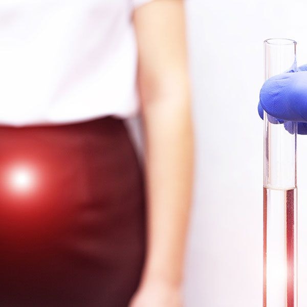 Close up of test tube and a woman in the background