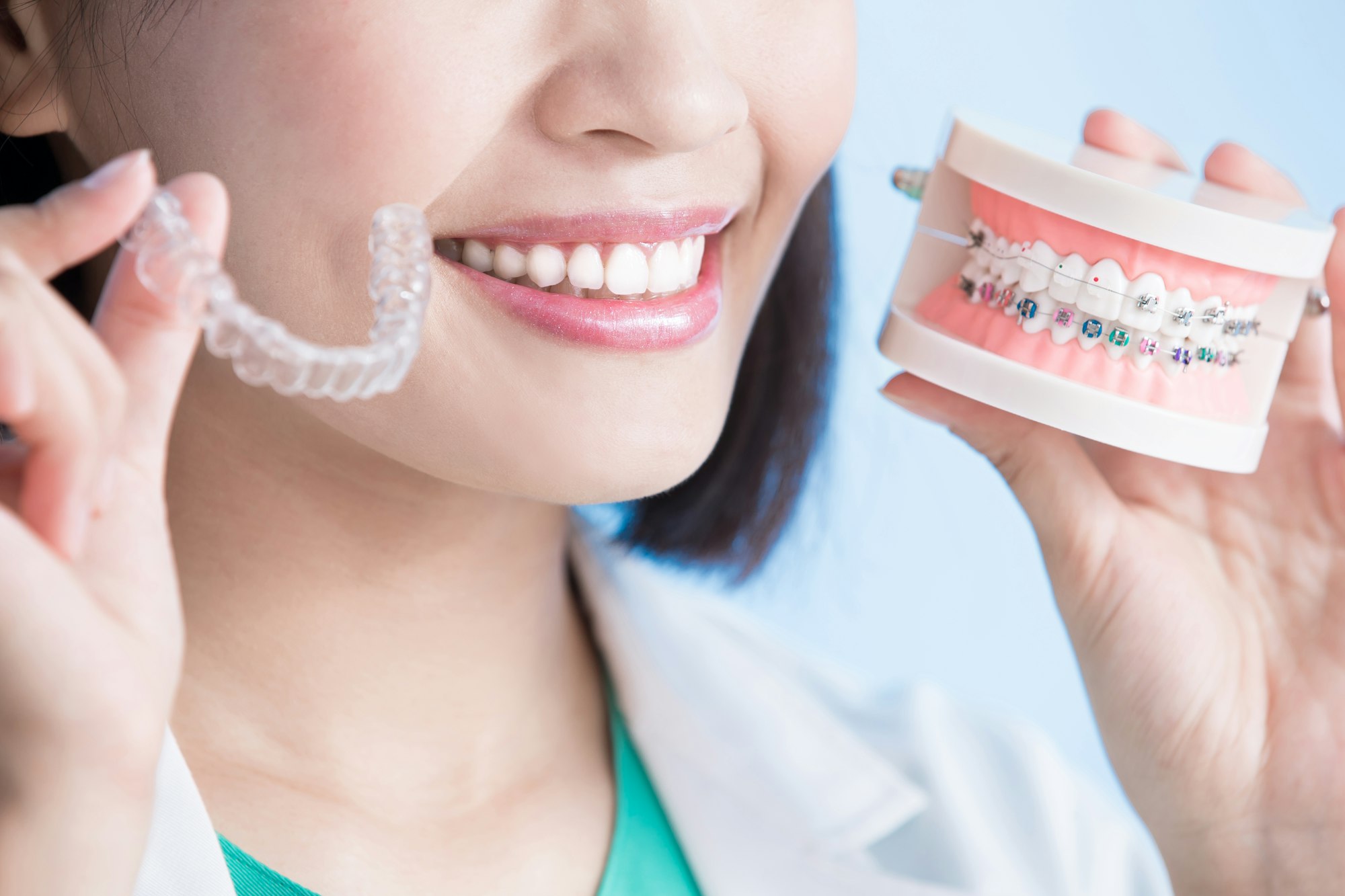 woman holding braces and invisalign