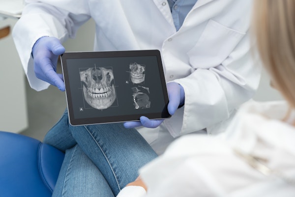 Dentist showing dental x-ray to patient