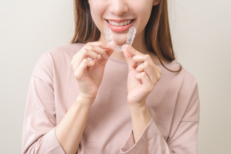 woman holding invisalign aligner
